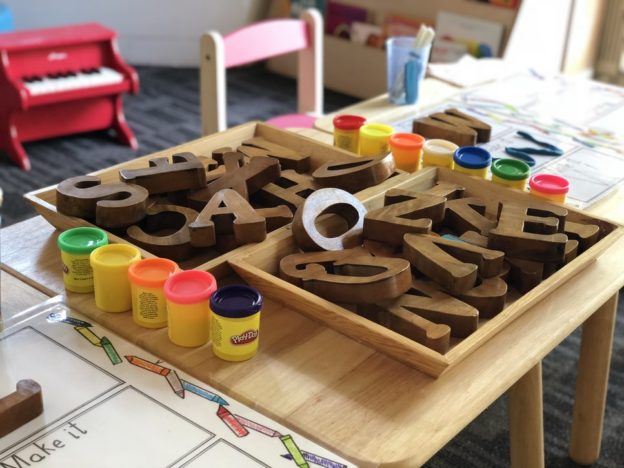 Table with wooden letters and play do